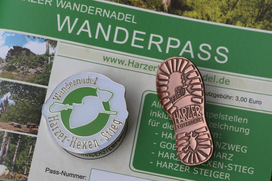Ein Wanderpass der Harzer Wandernadel mit Wanderabzeichen. (Archivbild)