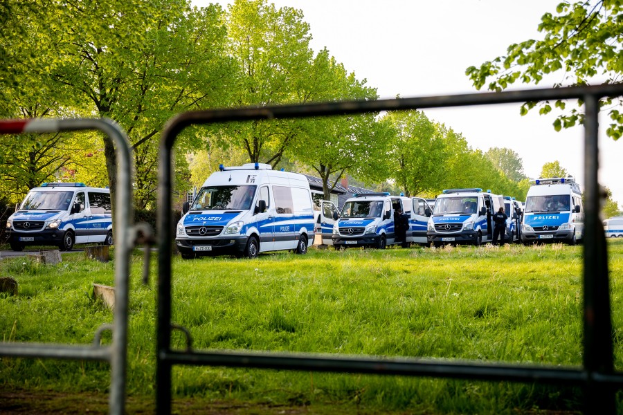 Polizeifahrzeuge stehen auf einer Wiese in der Nähe der Veranstaltungsstätte eines Sonderparteitages der AfD Niedersachsen.