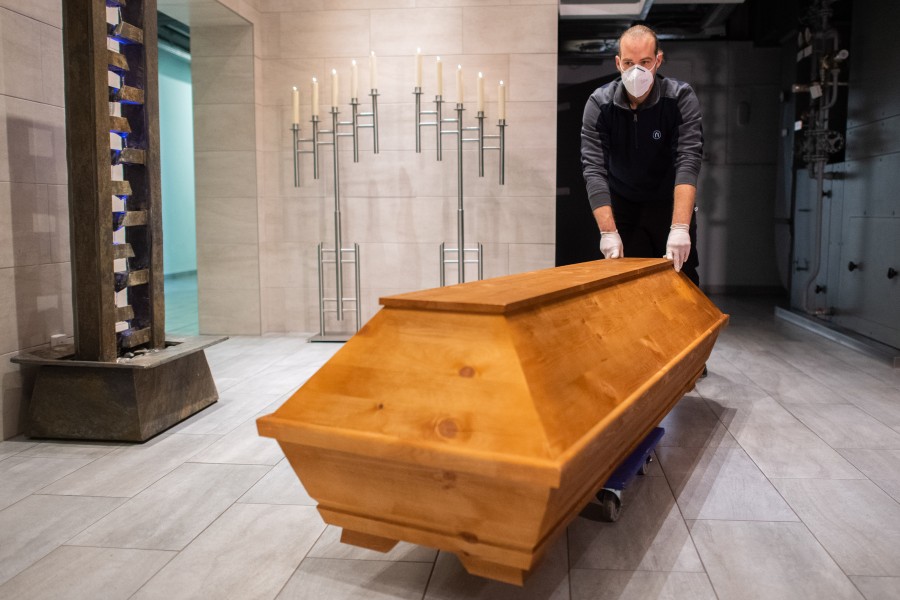 Benjamin Kuhn, Kremationstechniker, schiebt im Krematorium Celle einen Sarg zur Einäscherung zu einem Ofen.