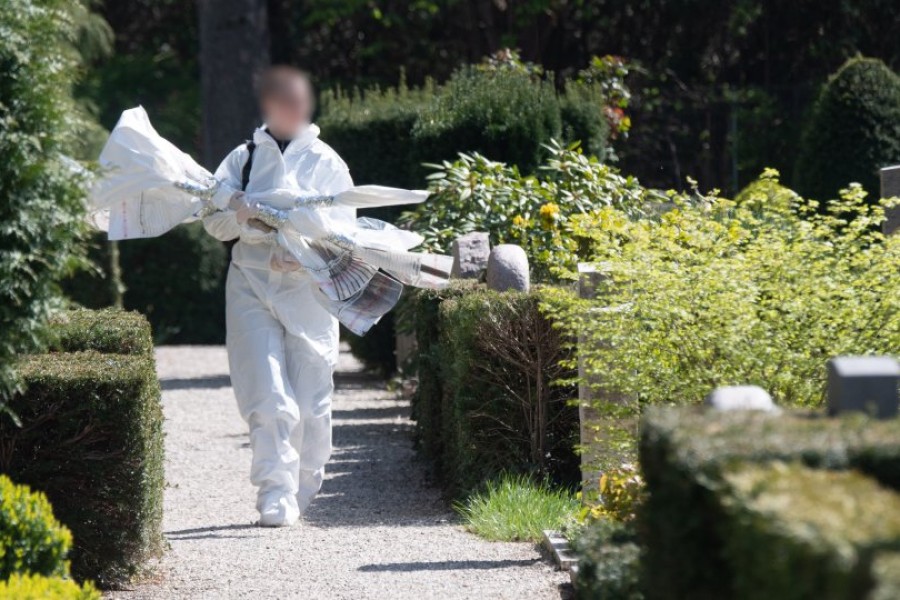 Eine Mitarbeiterin der Spurensicherung der Polizei Hannover trägt Beweismaterial über einen Friedhof im Stadtteil Kirchrode. Friedhofsmitarbeiter hatten hier die Leiche von Kadir A. gefunden.
