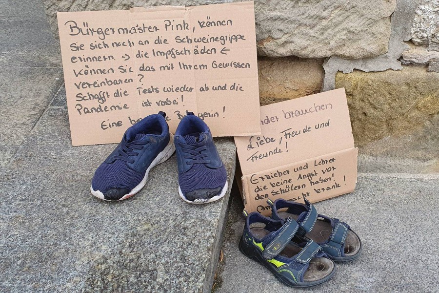 Eine „besorgte Bürgerin“ legte die Plakate samt Schuhe und Sandalen vor dem Rathaus ab.
