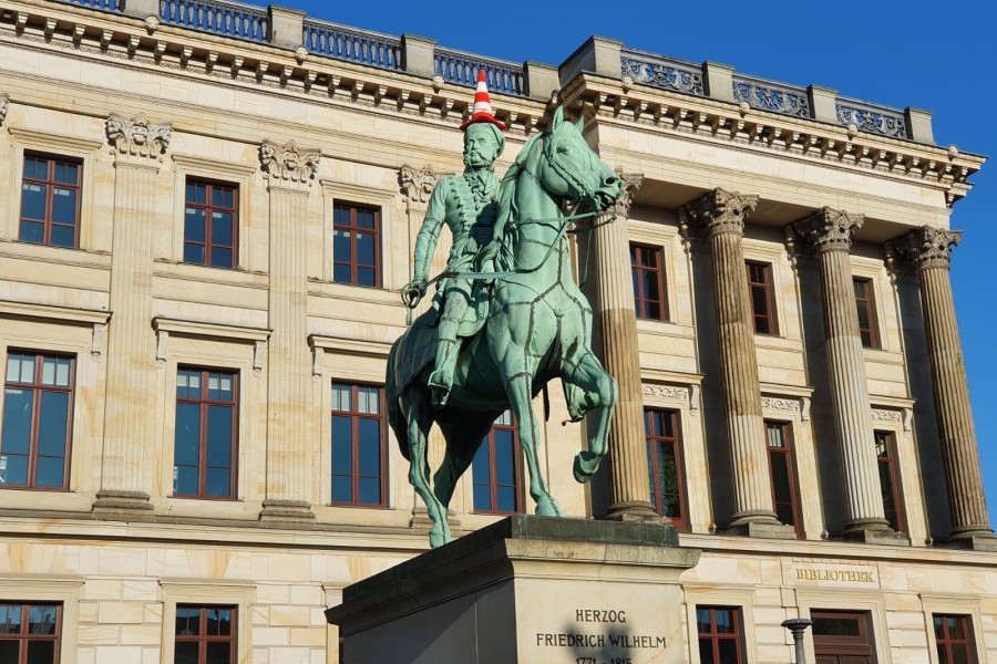 Braunschweig: Die Statue von Herzog Friedrich Wilhelm mit einer Pylone auf dem Kopf.