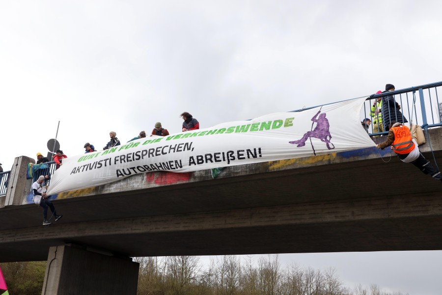 Die Demonstranten seilten sich von einer Brücke ab. Auf dem Transparent steht: „ Gurt an für die Verkehrswende“.