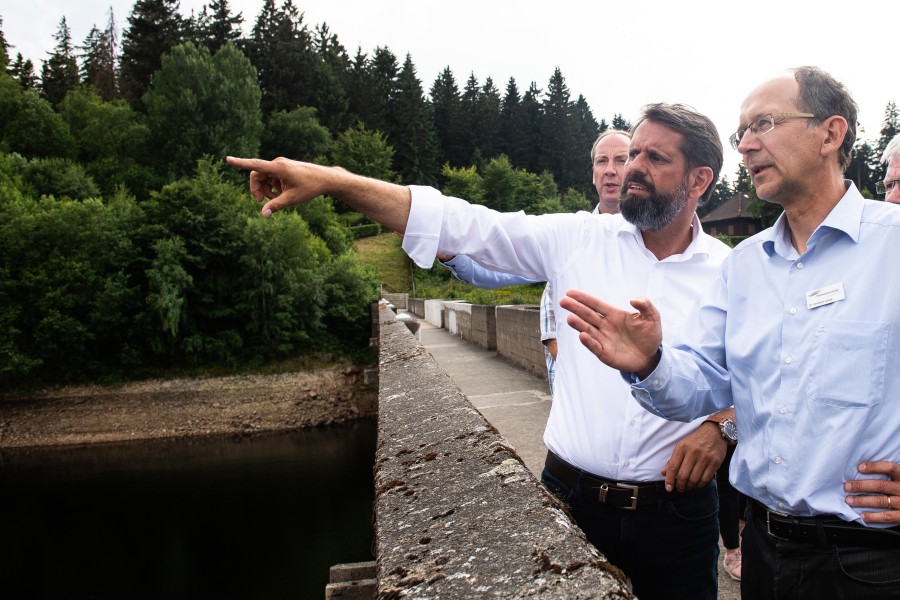 Olaf Lies (links, SPD), Umweltminister von Niedersachsen, steht während seiner Sommerreise mit Andreas Lange, Bereichsleiter Betrieb der Harzwasserwerke, auf der Staumauer der Eckertalsperre im Harz. 