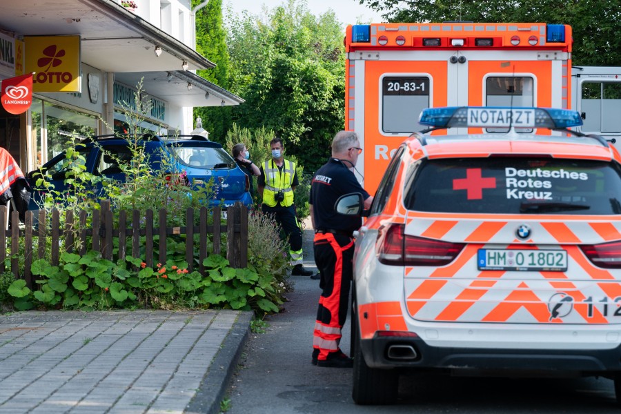 Einsatzkräfte von Rettungsdienst und Polizei stehen nach einem Unfall an einem Kleinwagen. Ein 76-jähriger Mann ist am Morgen in der Region Hannover mit seinem Fahrzeug in eine Schaufensterscheibe gekracht und gestorben. 