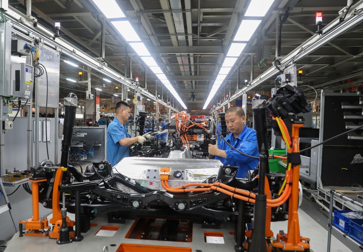 chinesische VW Mitarbeiter schrauben am Auto