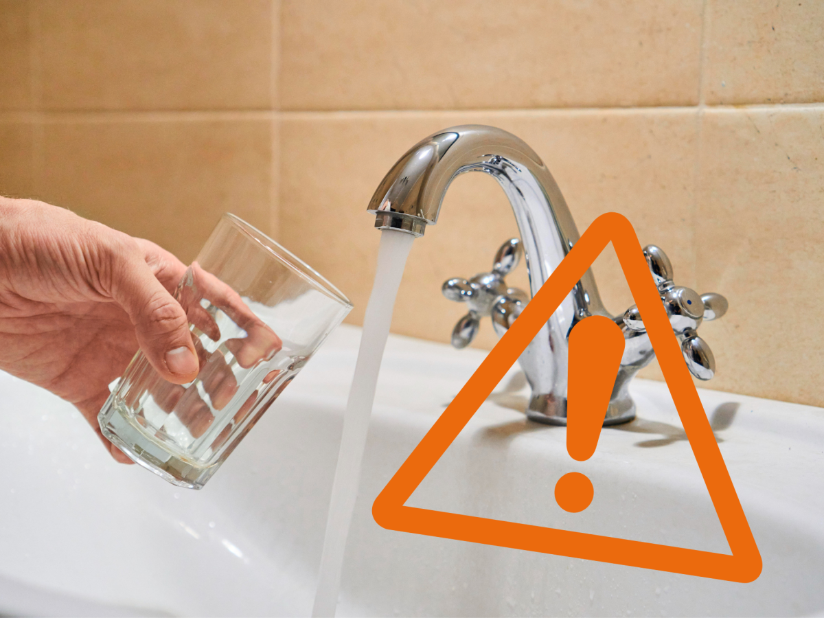 Glas wird unter Wasserhahn gehalten mit 