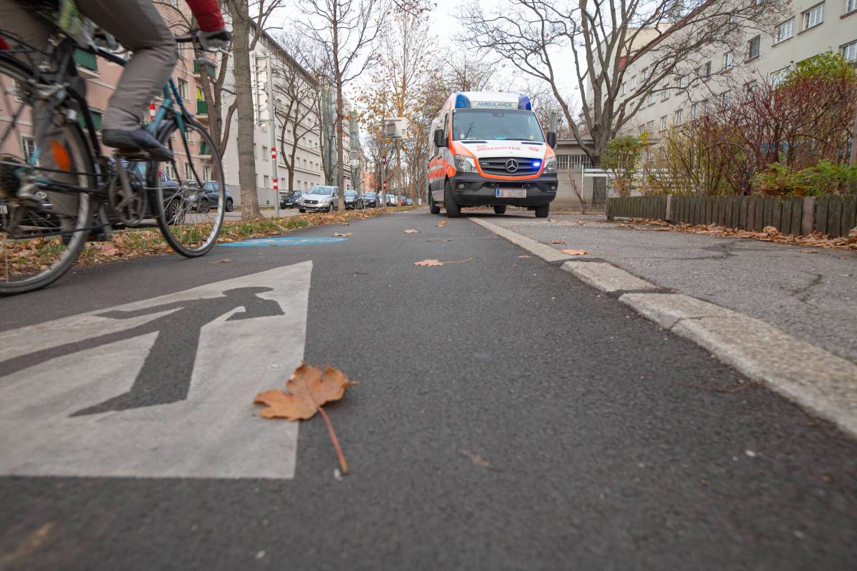 Fahrrad fährt auf Radweg, Rettungswagen steht dort