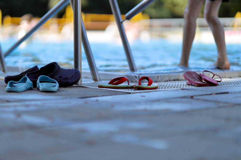 Schuhe stehen vor Schwimmbecken