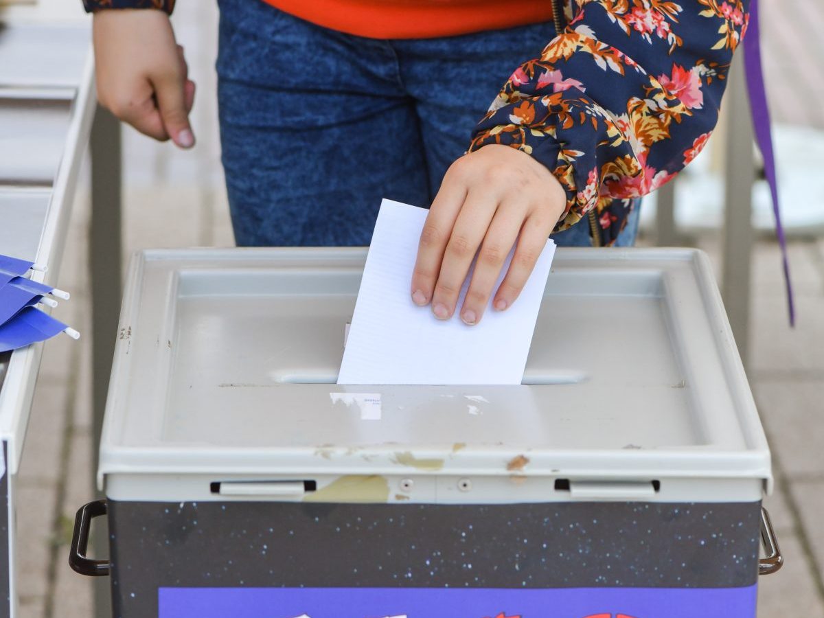 Mädchen steckt Zettel in Wahl-Urne