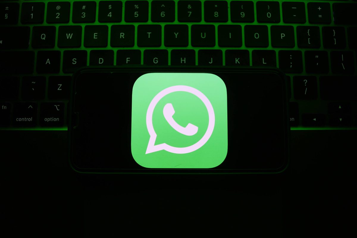 Whatsapp-Logo vor einer im Schatten verschwindenden Tastatur