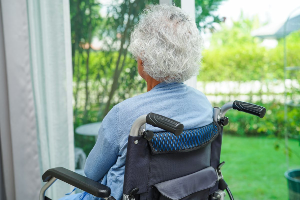 Braunschweig Frau sitzt im Rollstuhl vor ihrem Fenster