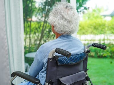 Braunschweig Frau sitzt im Rollstuhl vor ihrem Fenster