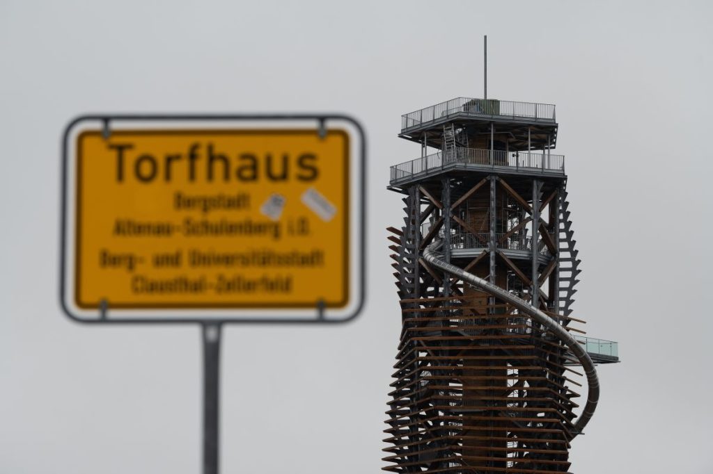 Blick auf den Harzturm hinter einem Ortsschild. Nach jahrelangen Verzögerungen beim Bau wird der Harzturm als neues Ausflugsziel in Torfhaus eröffnet.