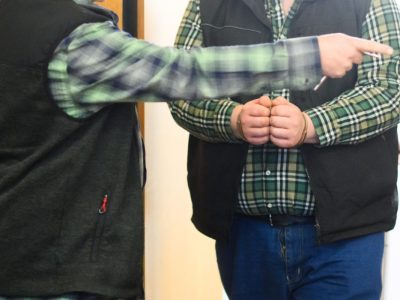 Der Angeklagte (r) kommt mit Handschellen ins Landgericht Hildesheim. Ein halbes Jahr nach der Tat muss sich der mutmaßliche Armbrustschütze von Peine vor Gericht verantworten.