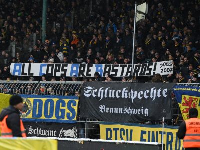 Die Fans von Eintracht Braunschweig zeigen Plakate gegen die Polizei.