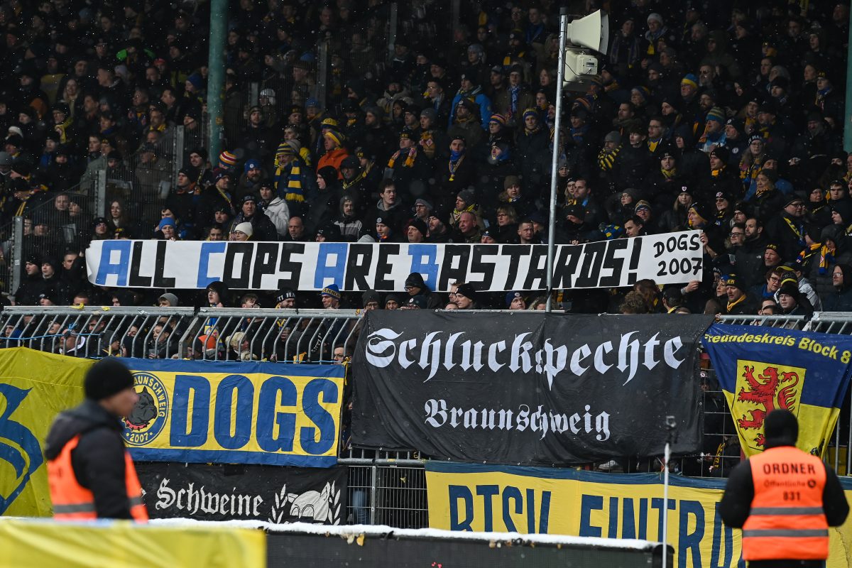 Die Fans von Eintracht Braunschweig zeigen Plakate gegen die Polizei.