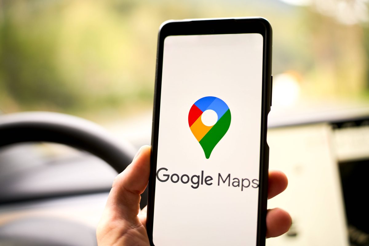 Google Maps Navigation Logo auf einem Smartphone in einem Auto vor einem Navi bzw. Navigationsgerät (Symbolbild für die Umbenennung einer Straße in Braunschweig)
